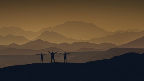 a couple of people standing on top of a mountain