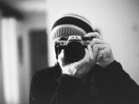 grayscale photo of person holding camera