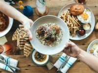 person holding white plate with food
